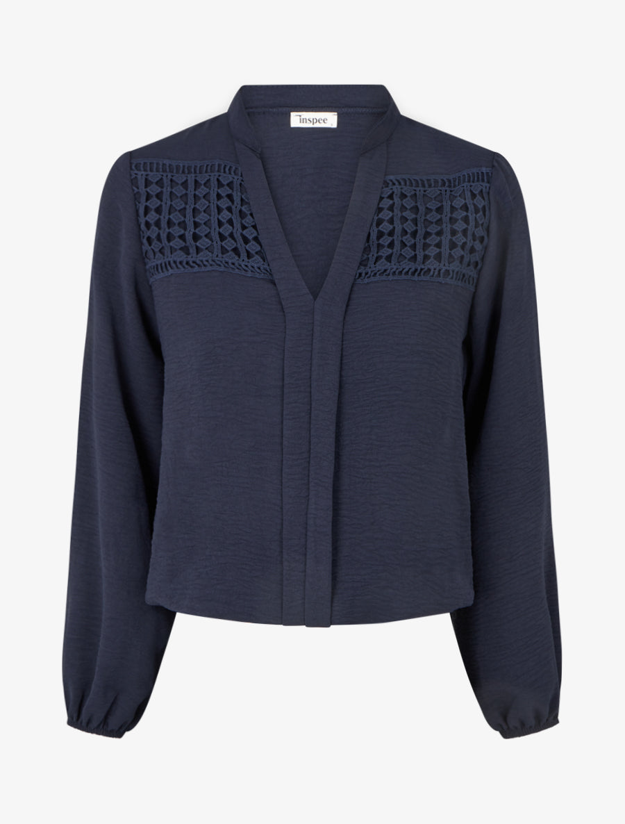 Blusa fluida con corte redondeado y detalle de ganchillo